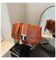 Detailaufnahme der braunen Krokodil-Leder-Handtasche mit elegantem goldnem Metallverschluss - Braun