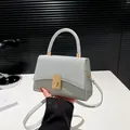 Piccola borsa a tracolla grigio argento con patta glitterata e chiusura girevole dorata - Argento