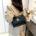 Bolso bandolera de piel negra acolchada con cadena dorada y cierre metálico - Negro