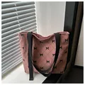 Detail der rosa Cord-Tragetasche mit schwarzen Schleifenmustern und Nylon-Schultergurten - Rosa