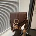 Minimalist dark brown PU leather saddle bag with wide patterned strap and golden buckle - Brown