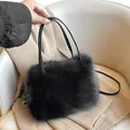 Schicke schwarze Kunstpelz-Tragetasche mit Lederriemen auf beigem Blazer-Hintergrund - Schwarz