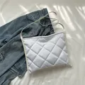 Borsa tote bianca in nylon trapuntato con manici in pelle su sfondo di stoffa - Bianco