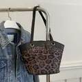 Retro-Shopper mit Leopardenmuster und schwarzen Griffen neben einer Jeansjacke - Schwarz
