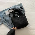 Minimalist black corduroy handbag with adjustable strap and white button detail - Black