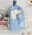 Detail eines blau-weißen Schulrucksacks mit Stern-Geldbörse und Toast-Anhänger - Blau