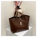 Dunkelbraune Shopper-Tasche aus glänzendem Leder mit goldenem Drehverschluss - Mit gewebtem Anhänger / Braun