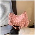 Detailed close-up of pink bubble textured cylinder bag with metallic hardware and flower charm - Pink