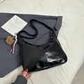 Glossy black shoulder bag with teddy bear charm and adjustable strap for women - With Pendant / Black