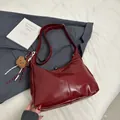 Minimalist burgundy patent leather crescent bag with bear charm and wide shoulder strap - With Pendant / Red