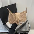 Quilted light coffee crescent shoulder bag with gold logo and tassel pendant detail - Khaki