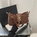 Dark brown crescent shoulder bag with geometric quilting and golden tassel logo - Brown
