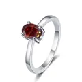Dettaglio di una gemma rossa ovale incastonata in un anello d'argento 925 a quattro punte - Rosso Granata