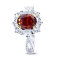 Macro shot of silver ring featuring oval red gemstone and cluster diamond setting - Garnet Red