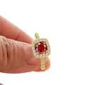 Luxurious gold engagement ring with round red stone and halo of white diamonds - US 5 / Garnet Red