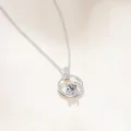 Dettaglio del ciondolo in argento S925 con moissanite a quattro griffe e piccoli diamanti - 1 Carato (6,5mm) / Bianco