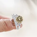 Champagne moissanite silver ring set with round main stone and pave band on finger - Original Yellow