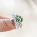 Luxurious 925 sterling silver ring featuring a large round green moissanite with diamond accents - Teal