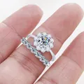 Detailed macro view of S925 silver moissanite ring set with sparkling halo and pave band - White
