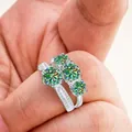 Macro shot of 925 silver rings with round-cut green moissanite gems and paved diamonds - Size 5 / Teal