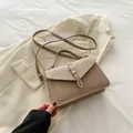 Borsa a tracolla in ecopelle kaki con manico e fibbia dorata su un blazer - Cachi