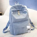 Close-up of light blue corduroy backpack with cute plush bear charm on white bedding - With Bear Pendant / Light Blue