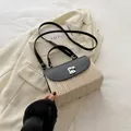 Strohhandtasche mit schwarzer Lederklappe und Metallschloss auf weißem Blazer - Schwarz