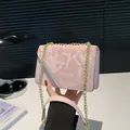 Borsa a tracolla rosa con stampa di lettere astratte e barra in metallo dorato - Rosa