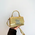 Chique gouden handtas met krokodillenreliëf, metalen B-logo en een klepsluiting - Goud