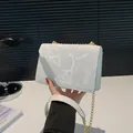 Elegante borsa a tracolla bianca con goffratura floreale e dettagli in catena dorata - Bianco