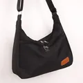 Minimalist black oxford cloth crossbody bag with dual zippers and adjustable strap - Black