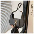 Detail of black crescent bag with cross-grain texture and gold hardware with tassels - Black