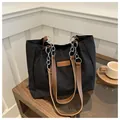 Detalle de bolso tote negro de nailon con parche de cuero y asas de cadena plateada - Negro