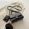 Minimalist black lychee leather handbag with gold metal buckle and matching small pouch - Black