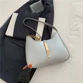 Minimalistische hellblaue Halbmond-Schultertasche aus Leder mit goldener Kette und Verschluss - Silber