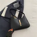 Minimalistische schwarze Leder-Halbmondtasche mit eleganter goldener Metallschnalle - Schwarz