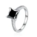 Vista macro di anello con pietra nera taglio princess e diamanti pavé su fascia argento - Nero