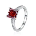 Anello in argento 925 con gemma rossa taglio princess e pietre laterali incastonate - Rosso granato