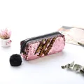 Detailed view of pink sequin pouch featuring black zipper and fuzzy pom-pom accessory - Pink