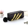 Vue détaillée de la trousse à paillettes noir et or avec un pompon en peluche douce - Noir