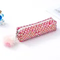 Dettaglio dell'astuccio rosa glitterato con rete a catena dorata, paillettes e pompon - Rosso rosa