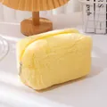 Soft yellow plush makeup bag with zipper closure shown in a cozy home setting decor - Light Yellow
