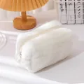Close-up of a soft white plush makeup bag with a zipper on a cozy, minimalist desk - Off-white