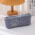 Dettaglio dell'astuccio a zampa di gatto in morbido peluche grigio-blu con ricamo e zip - Stile Ricamo Zampa di Gatto / Grigio