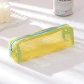 Detail of yellow mesh pencil case with light blue zipper on a minimalist sunlit desk - Small / Yellow