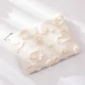 Dettaglio della borsa trucco bianca in peluche con texture a forma di cuore soffice - Bianco latte