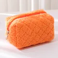 Close-up of bright orange plush pencil case with soft faux fur texture and silver zipper - Orange