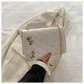 Weiße Stepptasche mit goldenen Schleifen-Verzierungen und eleganter Metall-Kettenriemen - Weiß