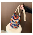 Detail of knitted bucket bag with colorful plush pompoms and wide shoulder strap - Khaki