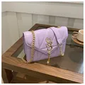 Dettaglio della borsa trapuntata lavanda con catena dorata e nappa decorativa - Viola